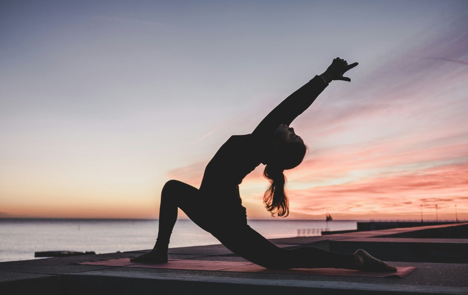 Woman practicing yoga in a peaceful setting, representing the connection between yoga, meditation, and radiant, healthy skin.